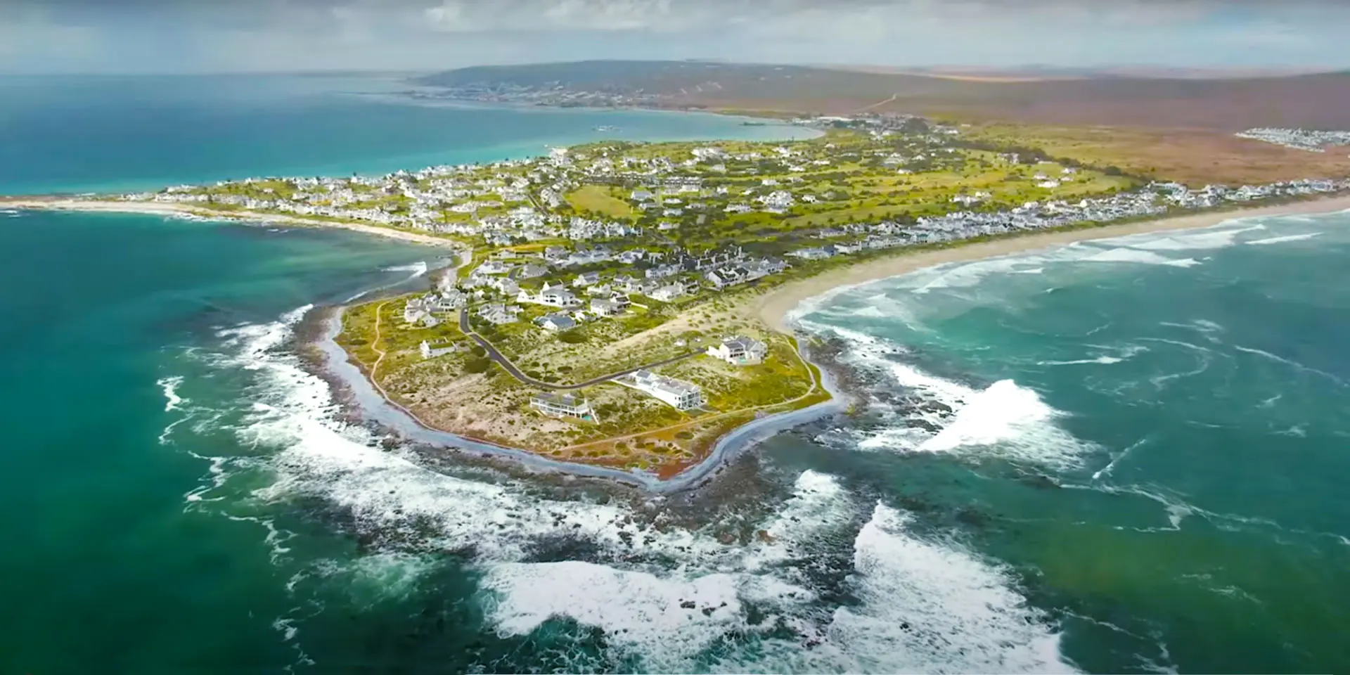 Aerial view of the Shelley Point peninsula surrounded by turquoise sea and white surf